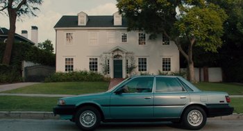 Movie still from “Lady Bird” (2017), directed by Greta Gerwig – A car is parked in front of a white house; Extreme Wide shot, Low angle