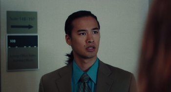 Movie still from “Lady Bird” (2017), directed by Greta Gerwig – A man in a brown suit and a blue tie; Close Up shot, Low angle