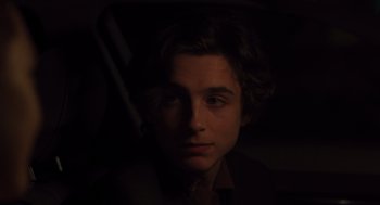 Movie still from “Lady Bird” (2017), directed by Greta Gerwig – A young man with dark hair is looking at the camera; Close Up shot, Over the shoulder angle