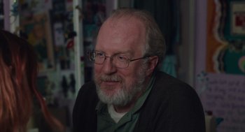 Movie still from “Lady Bird” (2017), directed by Greta Gerwig – An older man with a goatee wearing glasses; Close Up shot, Over the shoulder angle