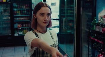 Movie still from “Lady Bird” (2017), directed by Greta Gerwig – A woman in a plaid shirt is holding a knife; Medium shot, Over the shoulder angle