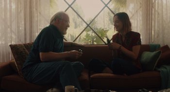Movie still from “Lady Bird” (2017), directed by Greta Gerwig – A man and a woman are sitting on a couch; Medium shot, Over the shoulder angle