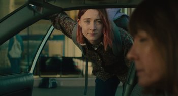 Movie still from “Lady Bird” (2017), directed by Greta Gerwig – A woman leaning on the side of a car looking out the window; Medium shot, Over the shoulder angle