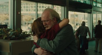 Movie still from “Lady Bird” (2017), directed by Greta Gerwig – An older man hugging a young girl in a room; Medium shot, Over the shoulder angle