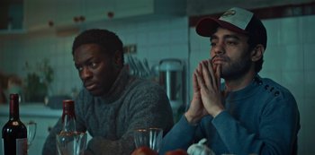 Movie still from “Marianne” (2019), created by Samuel Bodin – Two men sitting at a table with their hands clasped together; Medium shot, Low angle