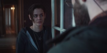 Movie still from “Marianne” (2019), created by Samuel Bodin – A young woman standing in front of an open window; Close Up shot, Over the shoulder angle