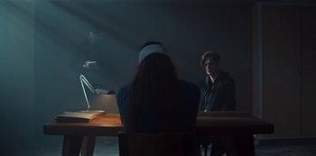 Movie still from “Marianne” (2019), created by Samuel Bodin – Two people sitting at a table in front of a mirror; Wide shot, Over the shoulder angle