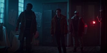 Movie still from “Marianne” (2019), created by Samuel Bodin – A group of people standing in front of a door; Medium shot, Low angle
