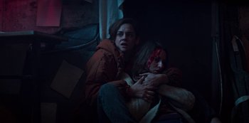 Movie still from “Marianne” (2019), created by Samuel Bodin – A man and a woman are sitting on the ground; Medium shot, High angle