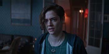 Movie still from “Marianne” (2019), created by Samuel Bodin – A person with long brown hair wearing a green shirt; Close Up shot, Over the shoulder angle