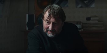 Movie still from “Marianne” (2019), created by Samuel Bodin – A person sitting in a room; Close Up shot, Low angle