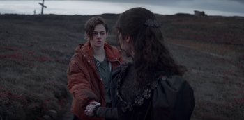 Movie still from “Marianne” (2019), created by Samuel Bodin – Two people are shaking hands in a field; Medium shot, Over the shoulder angle