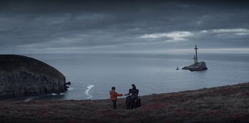 Movie still from “Marianne” (2019), created by Samuel Bodin – Two people standing on a hill near the ocean; Extreme Wide shot, Over the shoulder angle