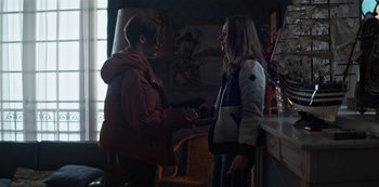 Movie still from “Marianne” (2019), created by Samuel Bodin – Two young women standing next to each other in a living room; Medium shot, Over the shoulder angle