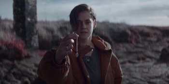 Movie still from “Marianne” (2019), created by Samuel Bodin – A person holding a small object in their hand; Close Up shot, High angle
