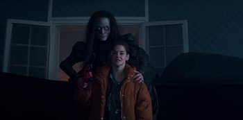 Movie still from “Marianne” (2019), created by Samuel Bodin – A woman standing next to another woman holding a drill; Medium shot, Over the shoulder angle