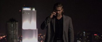 Movie still from “Miami Vice” (2006), directed by Michael Mann – A man talking on a cell phone while wearing a suit; Medium shot, Low angle