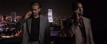 Movie still from “Miami Vice” (2006), directed by Michael Mann – Two men standing in front of a city skyline at night; Medium shot, Low angle