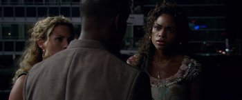 Movie still from “Miami Vice” (2006), directed by Michael Mann – A woman standing next to a man in front of a wall; Close Up shot, Over the shoulder angle