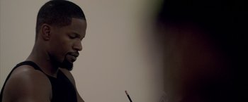 Movie still from “Miami Vice” (2006), directed by Michael Mann – A man holding a pencil and looking down; Close Up shot, High angle