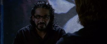 Movie still from “Miami Vice” (2006), directed by Michael Mann – A person wearing glasses and a black shirt; Close Up shot, Over the shoulder angle