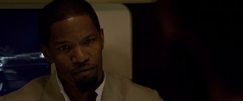 Movie still from “Miami Vice” (2006), directed by Michael Mann – A person wearing a suit and tie; Close Up shot, High angle