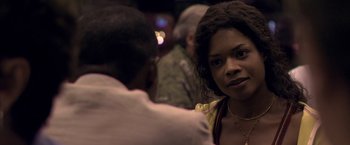 Movie still from “Miami Vice” (2006), directed by Michael Mann – A woman sitting next to a man in a room; Close Up shot, Over the shoulder angle