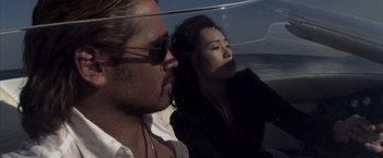 Movie still from “Miami Vice” (2006), directed by Michael Mann – A man and a woman sitting on a beach; Close Up shot, Low angle
