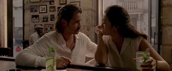 Movie still from “Miami Vice” (2006), directed by Michael Mann – A man and a woman sitting at a table talking to each other; Medium shot, Over the shoulder angle
