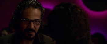 Movie still from “Miami Vice” (2006), directed by Michael Mann – A person wearing glasses and a jacket; Close Up shot, Over the shoulder angle