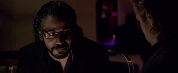 Movie still from “Miami Vice” (2006), directed by Michael Mann – A person wearing glasses and a black shirt; Close Up shot, Over the shoulder angle