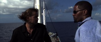 Movie still from “Miami Vice” (2006), directed by Michael Mann – A man standing on the deck of a boat in the ocean; Close Up shot, Over the shoulder angle