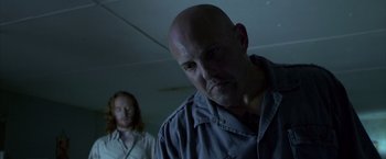 Movie still from “Miami Vice” (2006), directed by Michael Mann – A man with a bald head and a man with a long hair; Close Up shot, Low angle