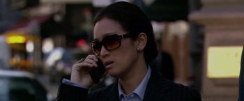Movie still from “Miami Vice” (2006), directed by Michael Mann – A woman wearing sunglasses talking on a cell phone; Close Up shot, Low angle