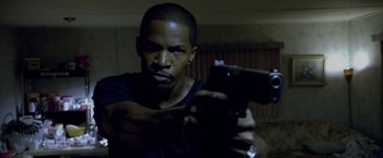 Movie still from “Miami Vice” (2006), directed by Michael Mann – A man holding a gun in a dark room; Close Up shot, High angle