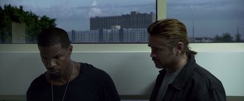 Movie still from “Miami Vice” (2006), directed by Michael Mann – Two men sitting next to each other in front of a window; Close Up shot, Over the shoulder angle