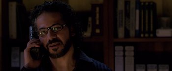 Movie still from “Miami Vice” (2006), directed by Michael Mann – A person wearing glasses and a beard; Close Up shot, Over the shoulder angle