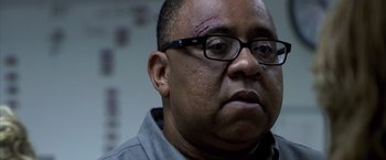 Movie still from “Miami Vice” (2006), directed by Michael Mann – A person wearing glasses and a shirt; Close Up shot, Low angle