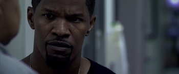 Movie still from “Miami Vice” (2006), directed by Michael Mann – A man's face in a black shirt; Close Up shot, Over the shoulder angle