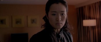 Movie still from “Miami Vice” (2006), directed by Michael Mann – A woman with long black hair wearing a black shirt; Close Up shot, Over the shoulder angle