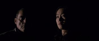 Movie still from “Miami Vice” (2006), directed by Michael Mann – A young woman with a cigarette in her mouth in the dark; Close Up shot, Low angle