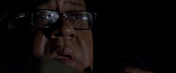 Movie still from “Miami Vice” (2006), directed by Michael Mann – A person wearing glasses; Extreme Close Up shot, Low angle