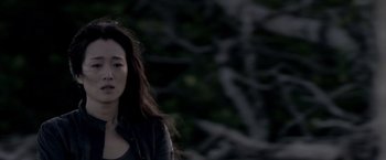 Movie still from “Miami Vice” (2006), directed by Michael Mann – A young woman standing in front of a tree; Close Up shot, Over the shoulder angle