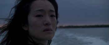 Movie still from “Miami Vice” (2006), directed by Michael Mann – A woman's face in front of a body of water; Close Up shot, Over the shoulder angle