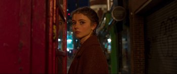 Movie still from “Last Night in Soho” (2021), directed by Edgar Wright – A young woman standing next to a building at night; Close Up shot, Over the shoulder angle