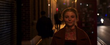 Movie still from “Last Night in Soho” (2021), directed by Edgar Wright – A young woman standing on a sidewalk at night; Close Up shot, Over the shoulder angle
