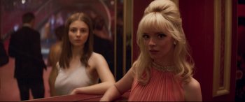 Movie still from “Last Night in Soho” (2021), directed by Edgar Wright – Two young women are looking into a mirror; Medium shot, Over the shoulder angle