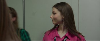 Movie still from “Last Night in Soho” (2021), directed by Edgar Wright – A woman in a pink shirt looking to the side; Close Up shot, Over the shoulder angle