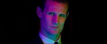 Movie still from “Last Night in Soho” (2021), directed by Edgar Wright – A person wearing a suit and tie; Close Up shot, Over the shoulder angle