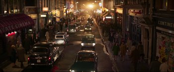 Movie still from “Last Night in Soho” (2021), directed by Edgar Wright – A busy city street at night filled with traffic; Extreme Wide shot, High angle